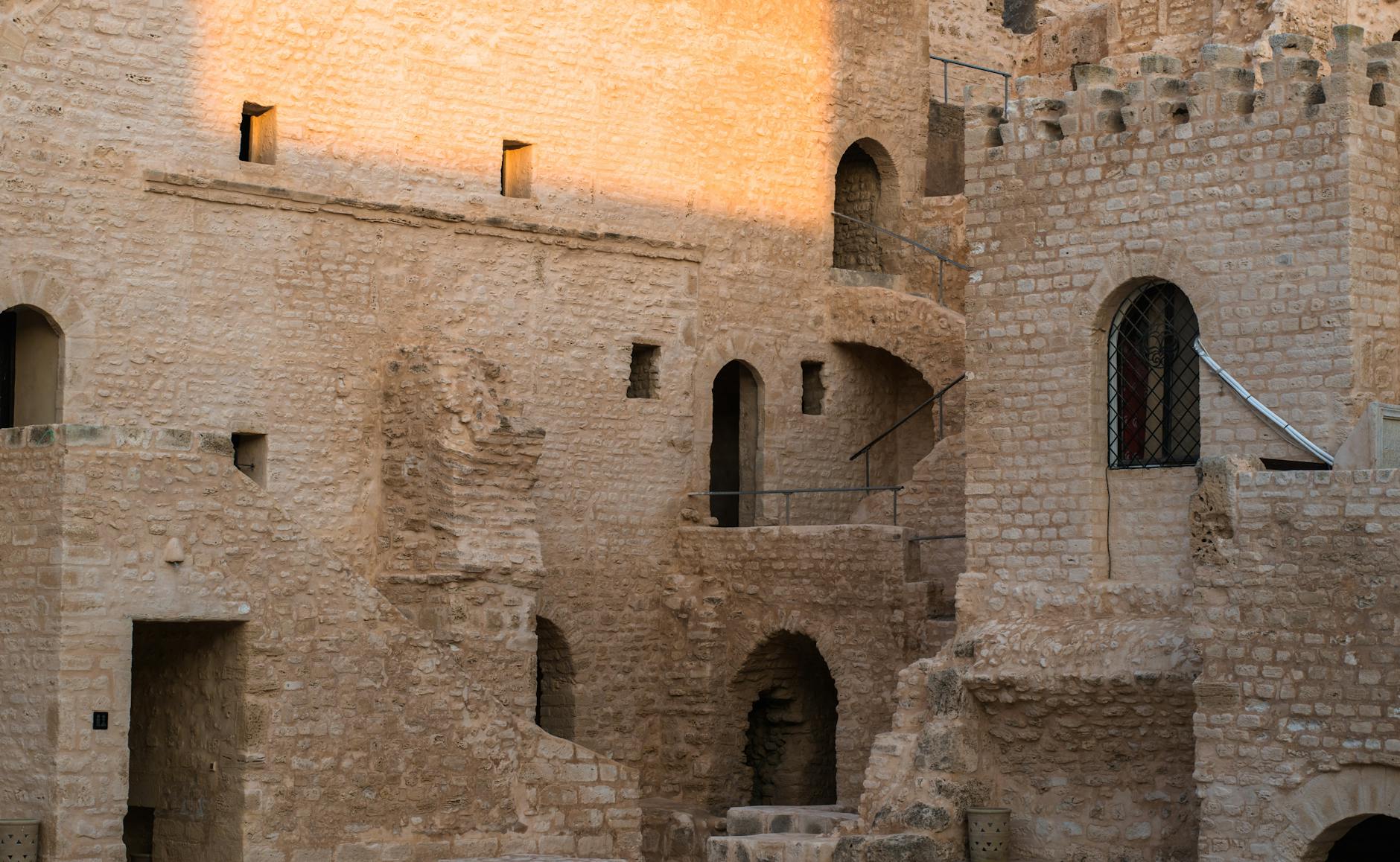 Gotyckie kamienne mury zamku w Szamotułach z łukami i ceglaną dekoracją