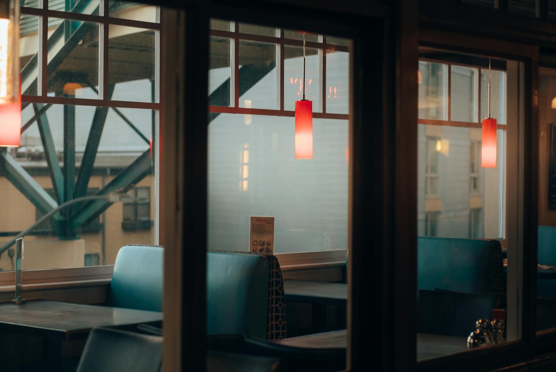 Pusty bar w ciepłym wieczornym świetle, czerwone lampy i niebieskie loże