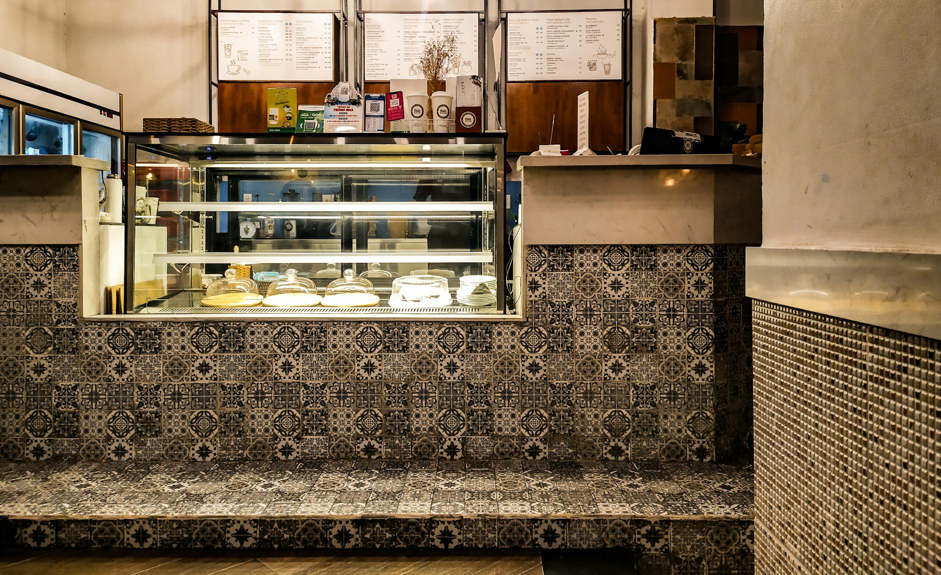 Elegancka kawiarnia z kafelkami i przeszkloną ladą z ciastami