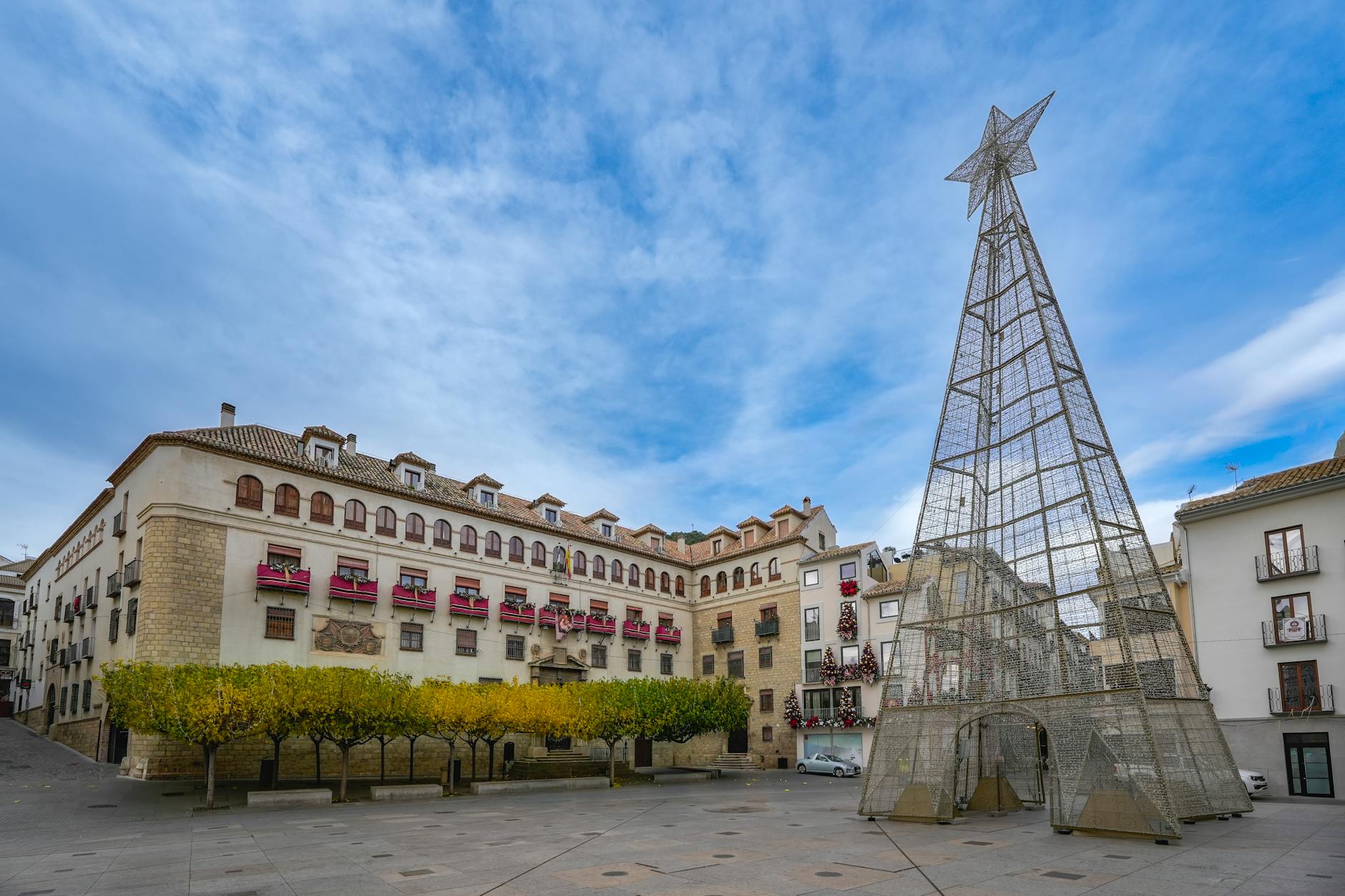 Świątecznie oświetlony plac miejski z dużą gwiazdą przed kamienicą