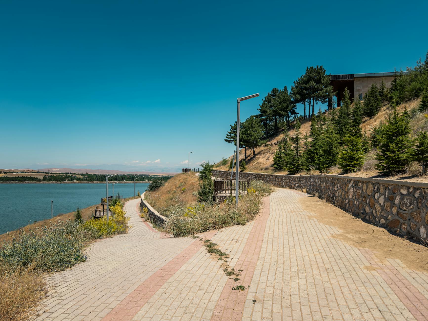 Ścieżka spacerowa nad spokojnym jeziorem otoczonym zielenią