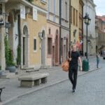 Kolorowe kamienice i spacerujący ludzie na klimatycznej ulicy Leszna