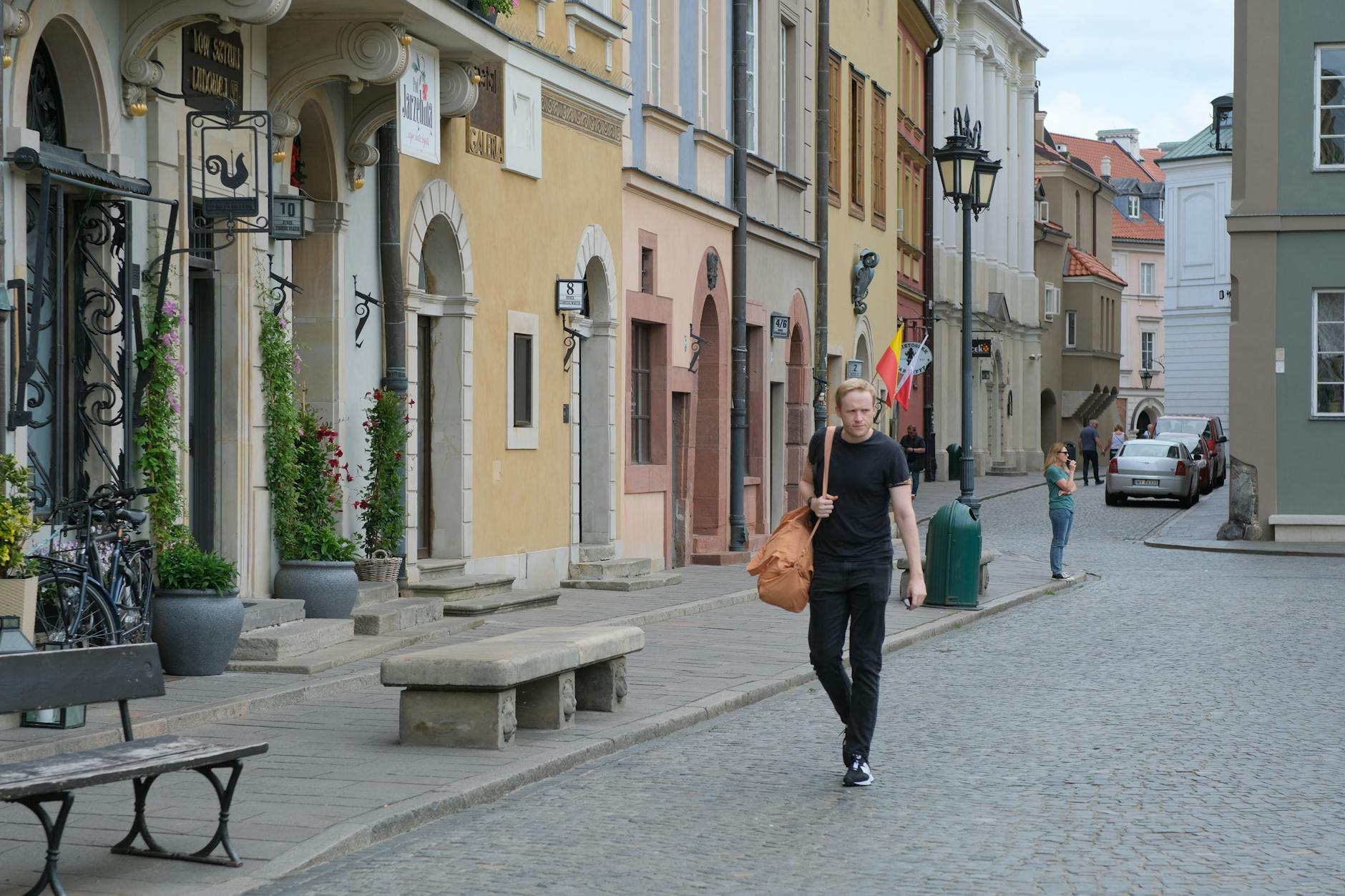 Kolorowe kamienice i spacerujący ludzie na klimatycznej ulicy Leszna