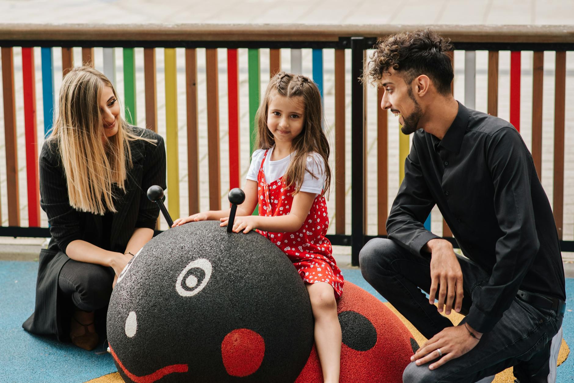 Rodzina z dzieckiem bawi się na placu zabaw na biedronce