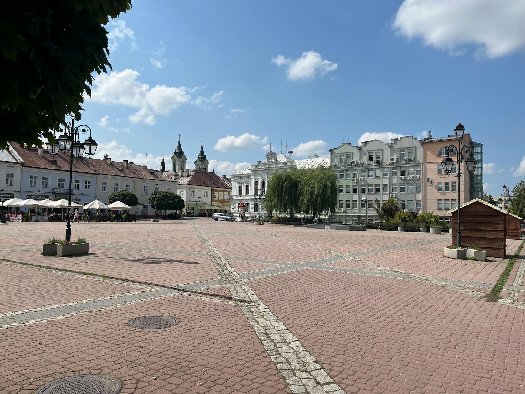 Słoneczny dzień na zabytkowym rynku z kamienicami w Sanoku